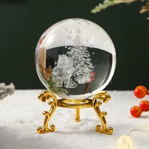 Detalle de una bola de cristal navideña grabada en 3D sobre un soporte dorado.