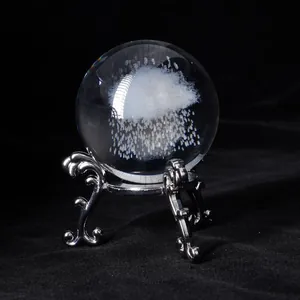 Detailed view of laser-engraved cloud pattern inside a crystal ball on ornate silver stand.