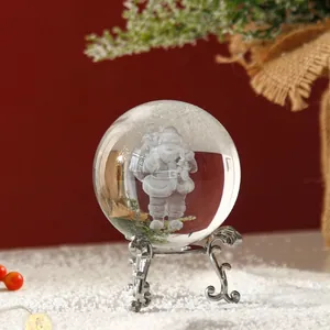 Primer plano de bola de cristal con grabado 3D de Papá Noel sobre soporte plateado