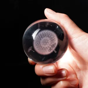 Detailed view of a clear crystal ball with internal 3D laser-engraved dandelion