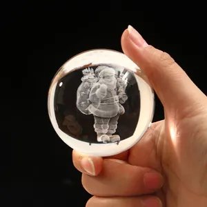 Detail of hand holding a laser engraved crystal ball featuring a 3D Santa Claus