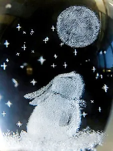 Close-up of laser engraved rabbit and moon inside a crystal glass ornament for desk
