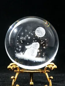 Macro view of a 3D laser engraved rabbit and moon crystal ball with a golden base.