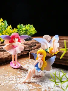 Set of three miniature fairy figurines placed on wood and sand for garden decor