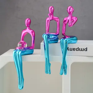 Detailansicht von drei modernen Kunstharzfiguren mit rosa-blauem Metallic-Farbverlauf
