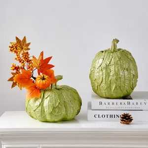 Détail du vase citrouille à texture de feuilles avec baies orange déco