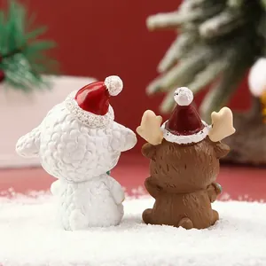 Vista trasera de figuras de oveja y reno con gorros de Papá Noel en la nieve