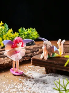 Close-up of two cute winged fairy figurines in a magical micro-landscape garden setting