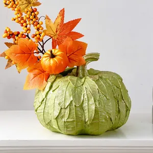 Vue détaillée d'un vase citrouille vert à texture de feuilles avec baies et feuilles d'automne.