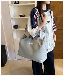 Modella con una grande borsa fitness grigia in un elegante ambiente domestico dettaglio