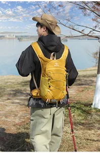 Vista dettagliata di un modello asiatico con zaino da trekking giallo sulla riva del lago.