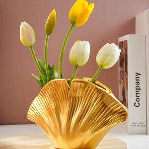Moderne minimalistische gouden hars vaas in schelpvorm met elegante kunst tulpen