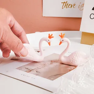 Gros plan de mignonnes figurines de cygnes en gomme rose avec couronnes orange pour décoration