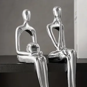 Primer plano de figuras abstractas plateadas en poses sentadas creativas para decoración
