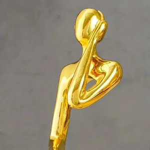 Close-up of a creative gold-plated abstract figurine showing smooth metallic texture