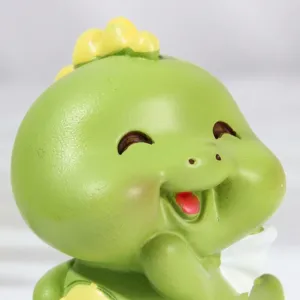 Primo piano di una graziosa figurina di dinosauro in resina verde con viso sorridente