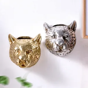 Decorative gold and silver leopard head wall planters with detailed metallic texture