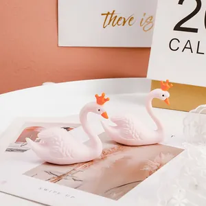 Gros plan de figurines de cygne en caoutchouc rose avec des couronnes orange décor