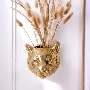 Detailed view of luxury gold leopard head wall mounted flower pot with dried grass