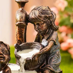 Primer plano detallado de una estatua de jardín de resina que muestra a una niña vertiendo agua