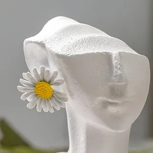 Primo piano di una scultura di viso astratta in resina bianca per un decoro minimalista.