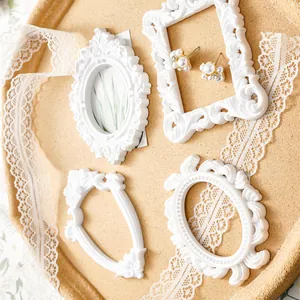 Detailed view of four white vintage European-style embossed frames on a cork background