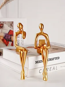 Vue détaillée de figurines de penseur abstrait dorées sur des livres blancs pour maison