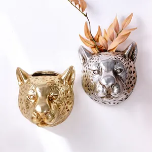 Close-up detail of leopard head wall planters showing metallic texture and form