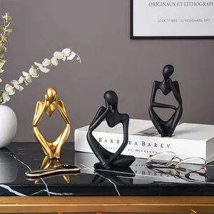 Set de tres figuras de pensadores abstractos nórdicos en oro y negro mate decorativas.