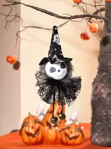 Detail view of a Halloween skeleton witch doll hanging on a branch with bell accents.