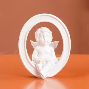 Escultura de ángel de resina blanca detallada en un marco decorativo con forma de O