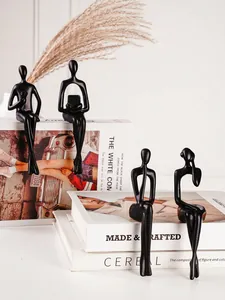 Statues de penseur noir abstrait sur des livres décoratifs pour décor de maison
