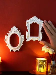 Close-up of vintage European style white relief wall frames on a textured red background