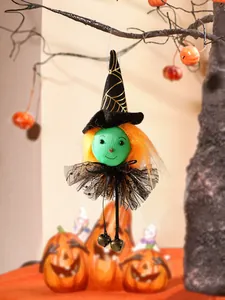 Detail view of a Halloween witch hanging ornament with green face and orange hair.
