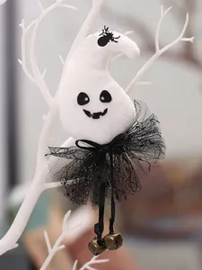 Close-up of cute plush ghost ornament with black tutu and bells hanging on a white branch