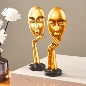 Detailed view of golden resin abstract face statues showing smooth and shiny metallic texture