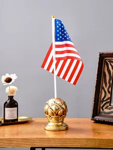 Vista detallada de una base de mástil dorada en forma de calabaza con bandera americana