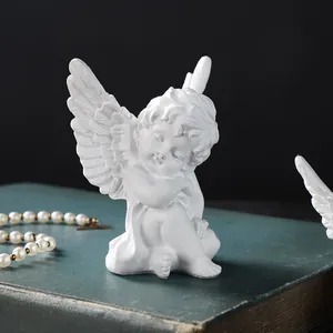 Close-up detail of a serene white resin angel figurine placed on a vintage book for decor