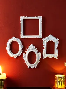 Vintage ornate white relief wall frame set on deep red wall with warm candlelight