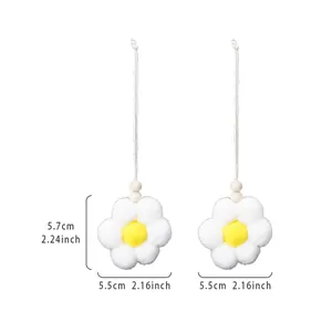Handmade white plush flower charm dimension diagram with wooden beads and hanging string.