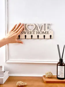 Detailansicht der 'Home Sweet Home' Holzwandhaken mit sechs schwarzen Metallaufhängern