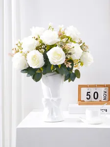 Elegant white artificial roses in a white ceramic vase with bow detail for home decoration