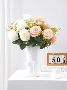 Detailed close-up view of artificial multi-head roses in a white bow-decorated ceramic vase