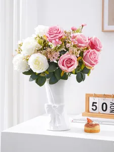 Detailed view of artificial multi-head roses in an elegant white ceramic bow flower vase