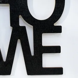 Primer plano macro de la decoración de pared de madera negra con textura de letras huecas
