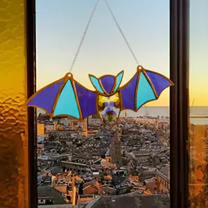 Close-up of stained glass bat pendant featuring vibrant wings and pressed flower body