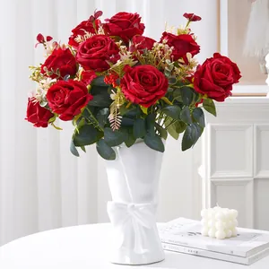 Elegant bouquet of artificial red roses in a white bow vase for wedding home decor