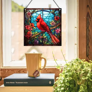 Primer plano de un atrapasol de vidriera con un cardenal rojo colgado en una ventana acogedora