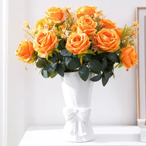 Elegant orange artificial multi-head rose bouquet in a white ceramic bow vase for home decor
