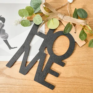 Primer plano de la letra decorativa HOME en madera negra con veta natural